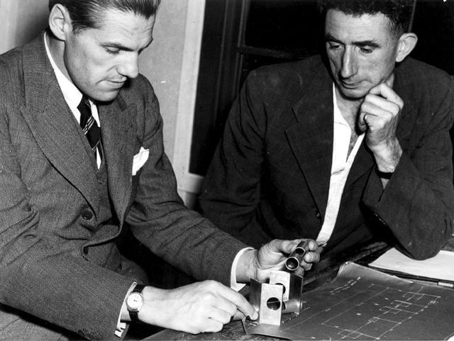 Richard Woolley and Jim Banham inspecting optical and mechanical components, optical munitions factory, 1944
