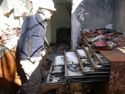 Peter Conroy looking through the plan files. Drawers full of melted plastic and ash.