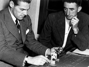 Richard Woolley and Jim Banham inspecting optical and mechanical components, optical munitions factory, 1944