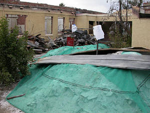 Ash piles, wetted down, ready to be packed into drums and carted off for burial.